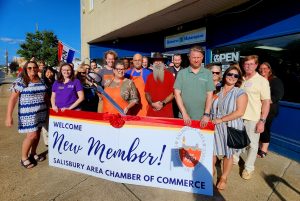 Large group of people standing behind a new member banner