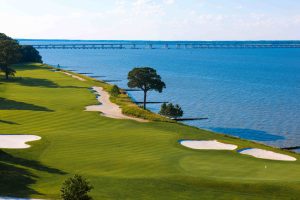 Golf course along the water with sand bunkers and trees