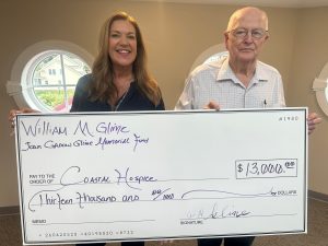 Coastal Hospice donation check held by a man and woman