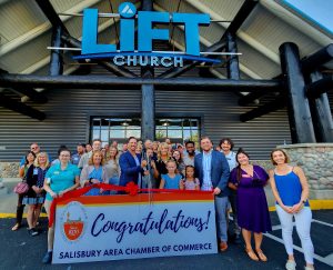 Group of people standing outside Lift Church with a congratulations sign