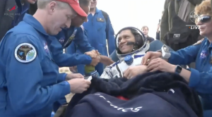 NASA Astronaut wearing his spacesuit and being congratulated by the NASA crewmates