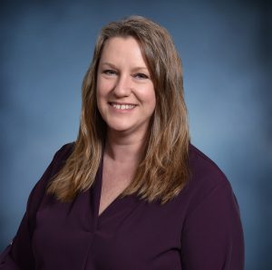 headshot of a woman in a purple blouse