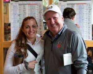 Woman holding a travel mug standing with a man in a gray pullover