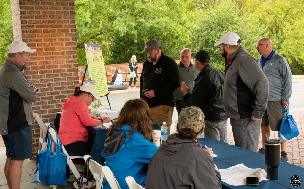 Group of golfers gathered around the registration table