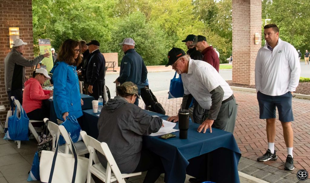 Group of golfers gathered around the registration table