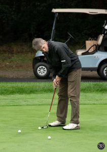 Golfer putting a golf ball on the golf course