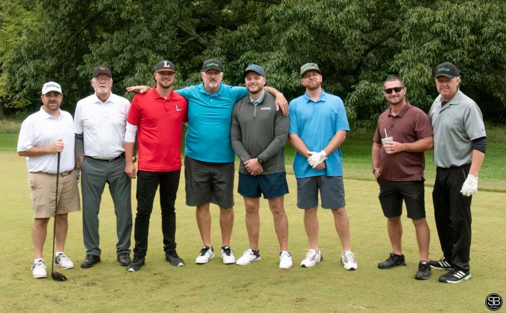 Group of 8 golfers standing on the golf course