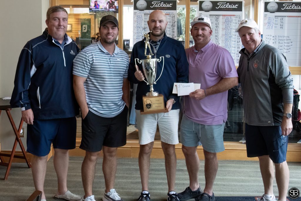 group of five guys posing with a golf trophy