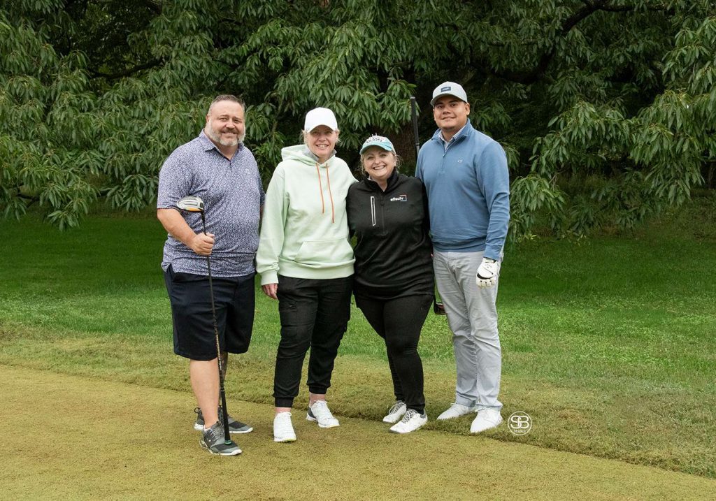 Golf Tournament Foursome of two men and two women standing on a golf course