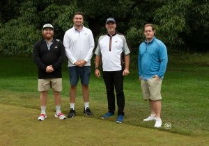 Golf Tournament Foursome of four men standing on a golf course