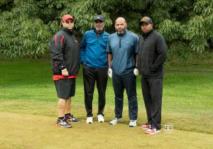 Golf Tournament Foursome of four men standing on a golf course