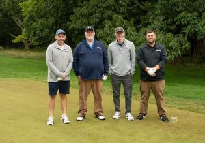 Golf Tournament Foursome of four men standing on a golf course