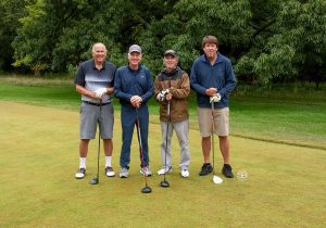 Golf Tournament Foursome of four men standing on a golf course