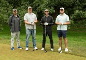 Golf Tournament Foursome of four men standing on a golf course