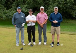 Golf Tournament Foursome of four men standing on a golf course