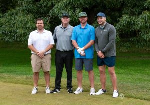 Golf Tournament Foursome of four men standing on a golf course