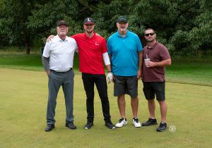 Golf Tournament Foursome of four men standing on a golf course