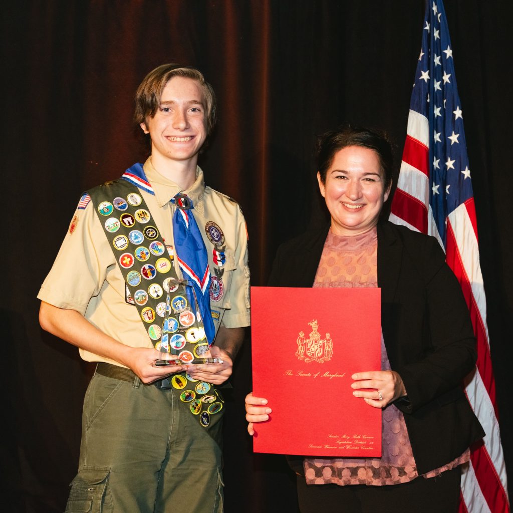 Young woman standing beside a boy scout on stage
