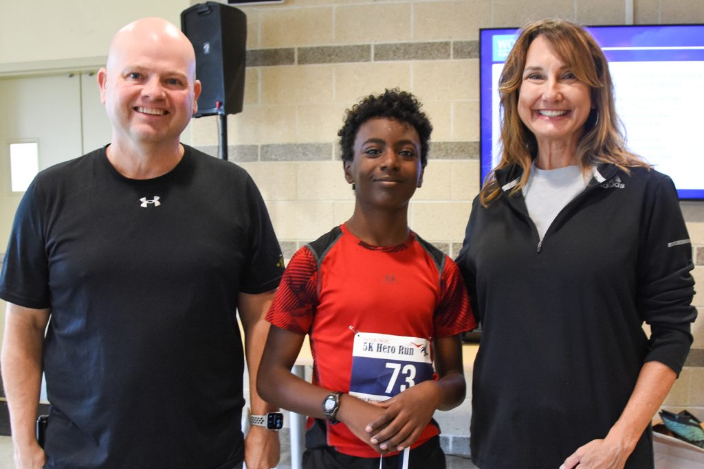 two men and a woman posing after a 5K race