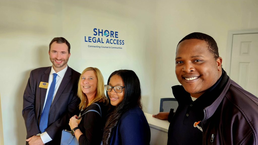 Four people standing in the Shore Legal Access office