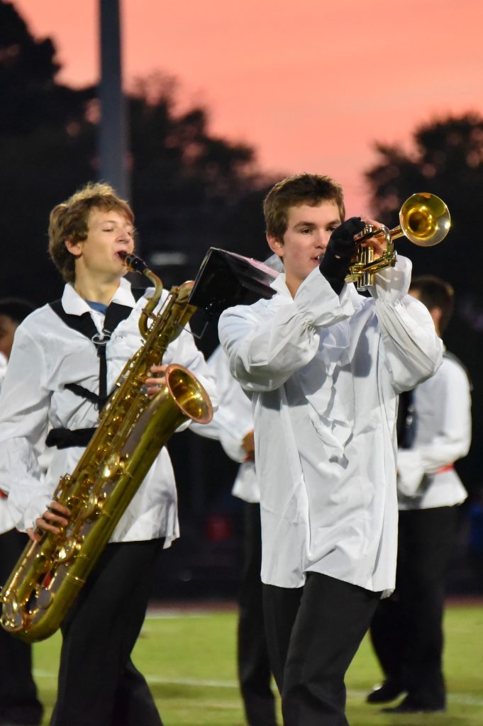 Two high school boys playing their instruments for the marching band
