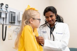 Pediatric female doctor examining a patient with a stethoscope