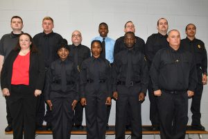 Several correctional officers from Somerset County standing against a white brick wall