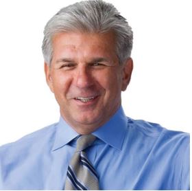 Headshot of an older man in a blue shirt and tie