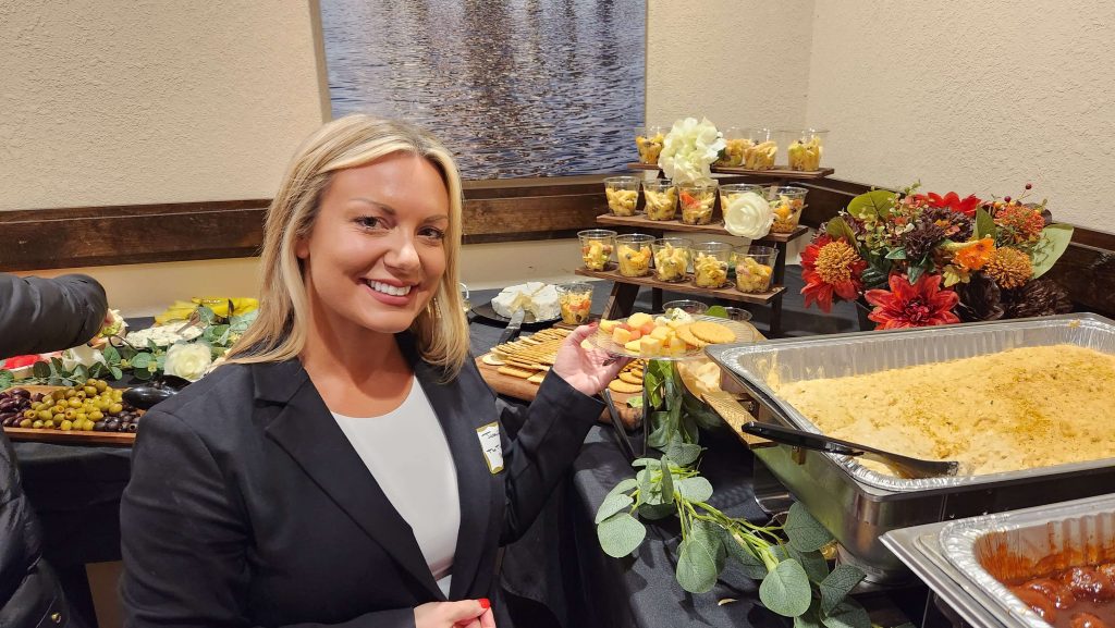 Smiling woman in front of a food table