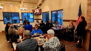 Room full of people sitting at dining tables