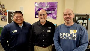 Three men standing next to each other at an event