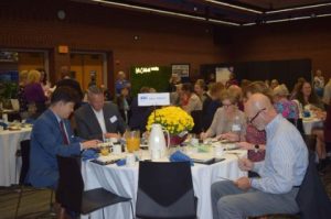 Men and women sitting around a table in a large event room at Salisbury University