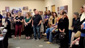 Large group of people standing indoors at a networking event