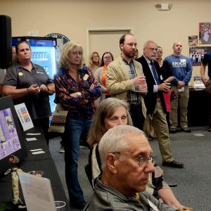 Men and women standing and sitting indoors at an event