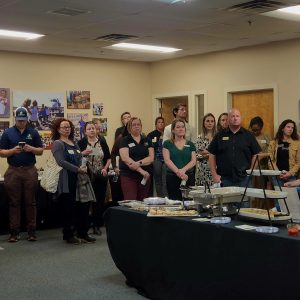 Large group of men and women standing indoors