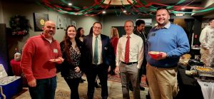 Group of adults in business attire at the AMP Studio Ribbon Cutting