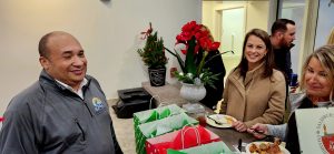 Gift bags on a counter wrapped in Christmas colors