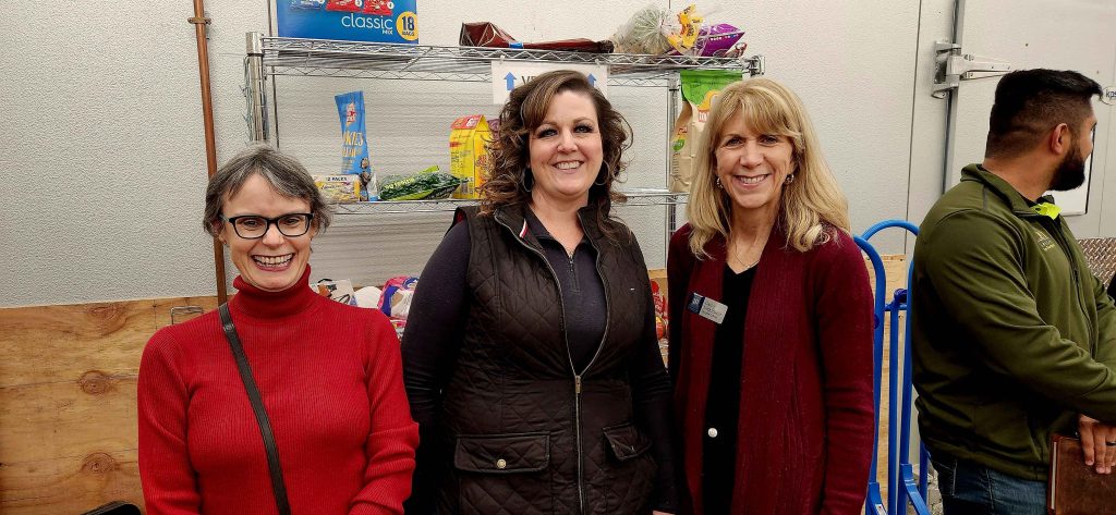 Three women standing together at the grocery Outlet