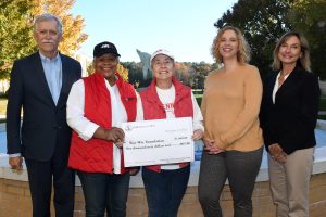 five people holding a large check for a donation to education