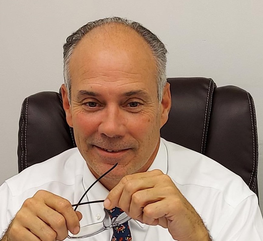 Headshot of a man holding glasses