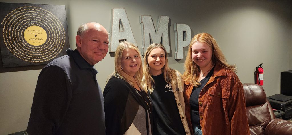 family of four celebrating the AMP Studio Ribbon Cutting