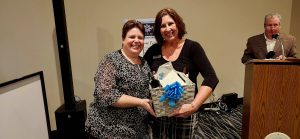 Two women holding a gift basket