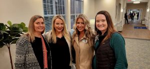 Four young women standing together