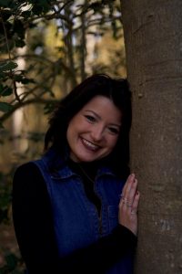 Headshot of Raven Cook against a tree