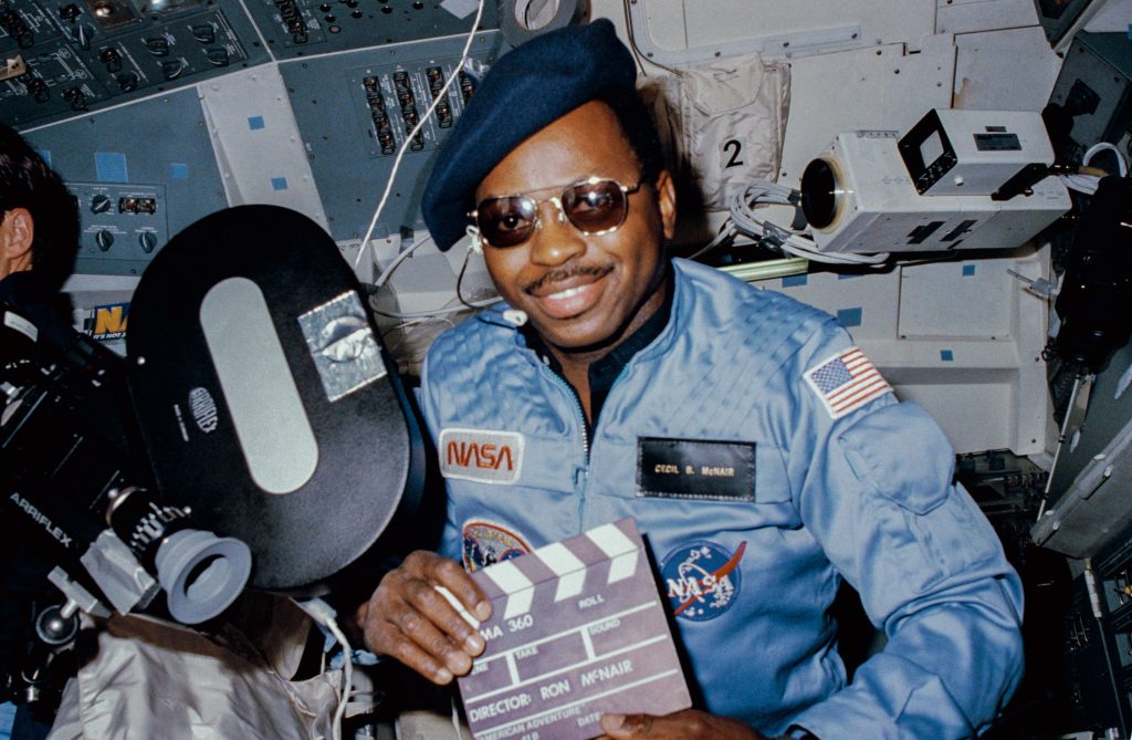 African American astronaut wearing a hat and sunglasses 