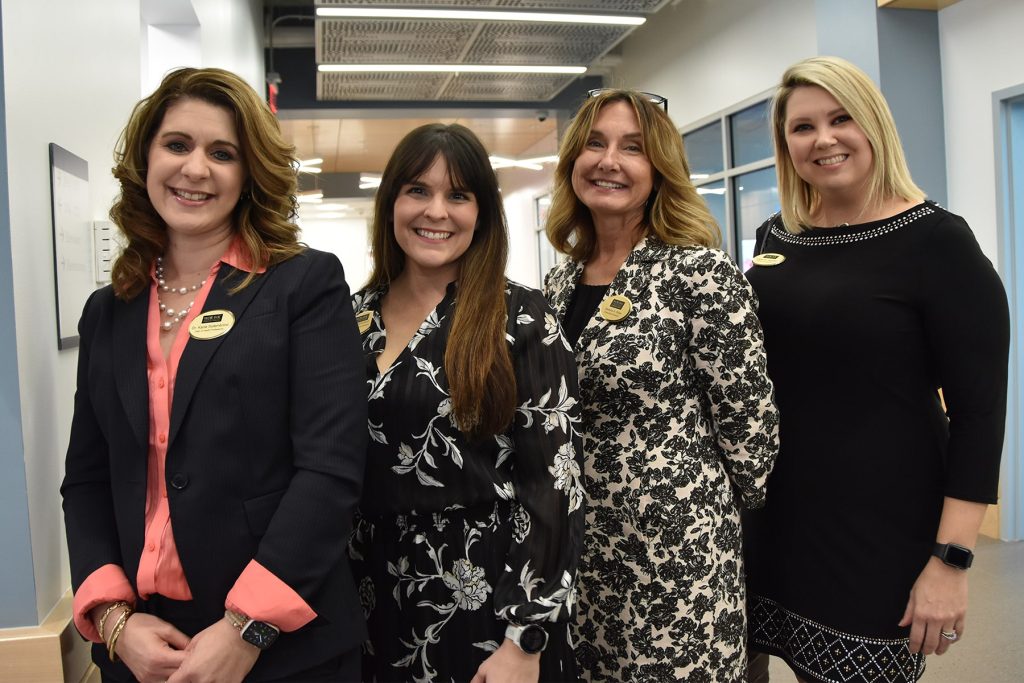 four women in business attire at a Chamber event