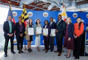 Maryland Governor, Wes Moor, standing beside minority women in business holding awards