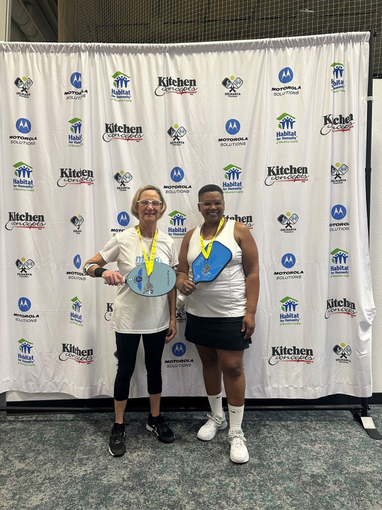 two people holding pickleball paddles