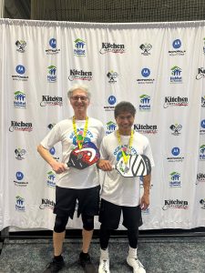 two men holding pickleball paddles