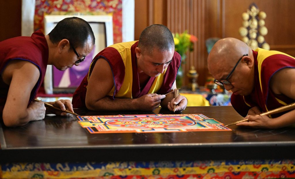 Three monks leaning over